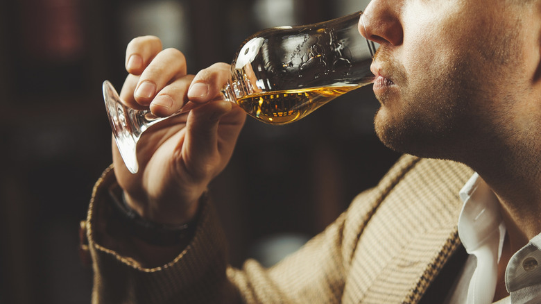 Man sipping glass of whiskey