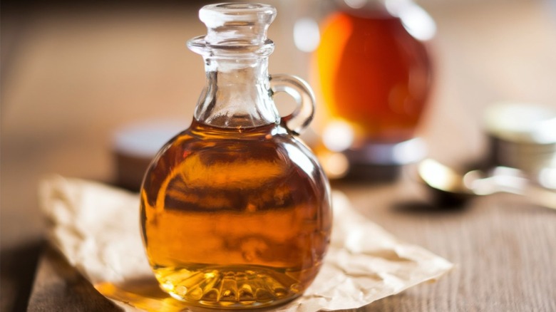 A glass jar of amber-colored syrup