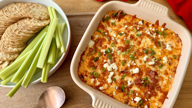 Crackers and celery next to Buffalo chicken dip