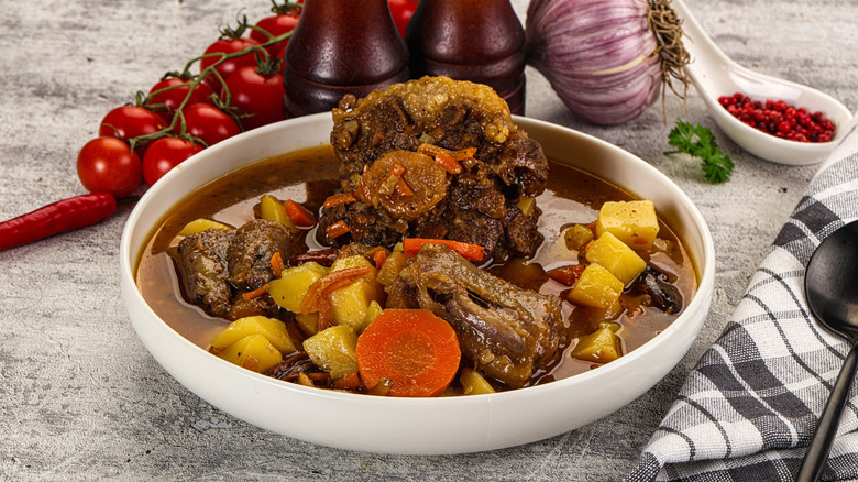 Plate of oxtail stew with gravy, potatoes, and carrots