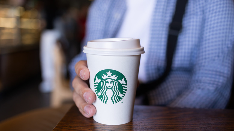 Person holding a Starbucks to go cup