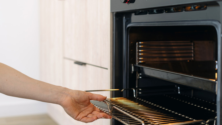 woman cleaning oven rack