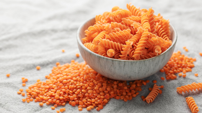 red lentils beside bowl filled with red lentil pasta