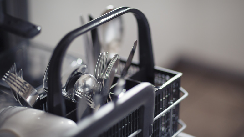 Various utensils in a dishwasher basket