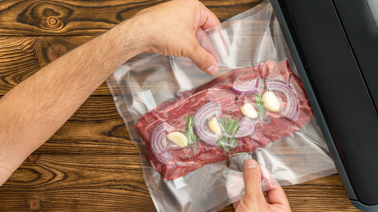 man using food sealer on steak and onions