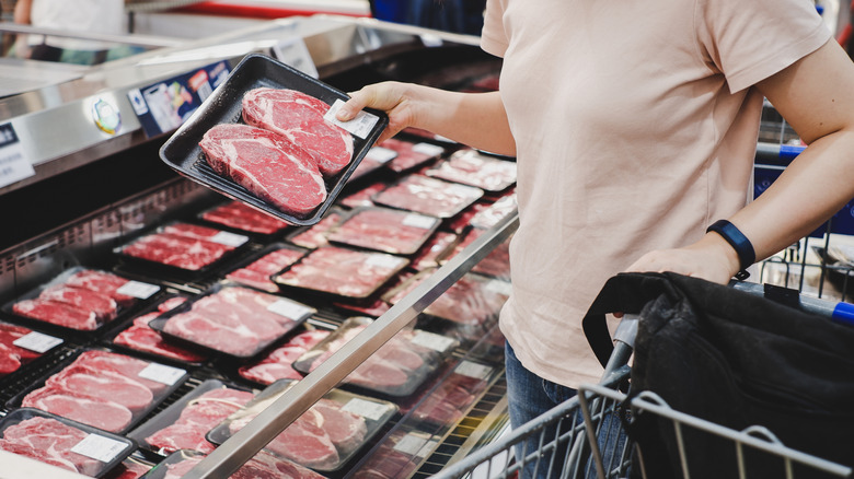 Person shopping for meat at supermarket