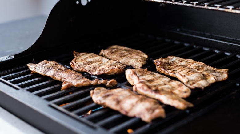 Turkey breasts cooking on a small gas grill