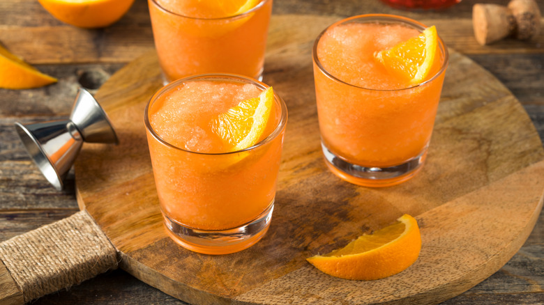 Three frozen Aperol spritzes on a wooden board