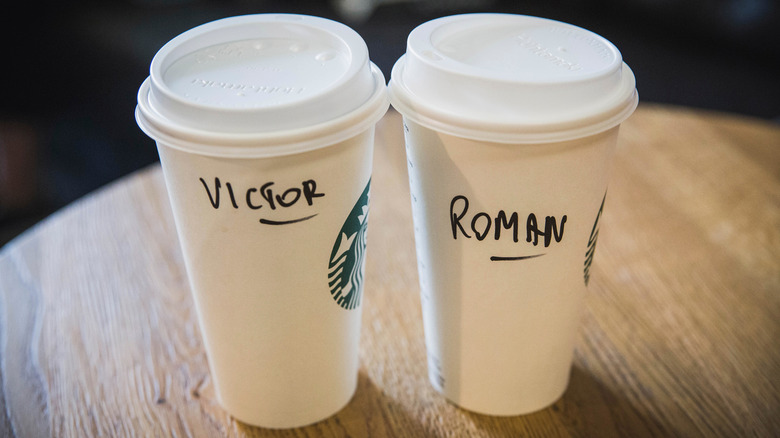 Two Starbucks cups with names written on them.