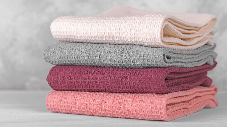 A stack of kitchen towels in various colors.