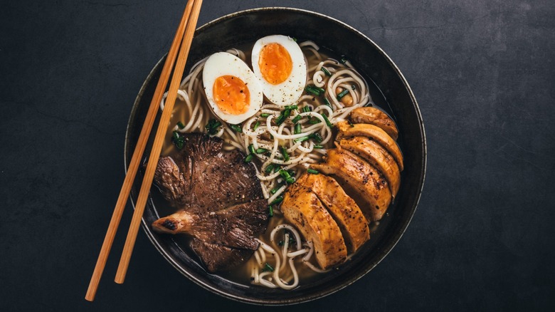 A bowl of ramen with chopsticks sitting on top.