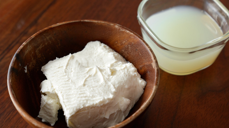 A bowl of drained yogurt and a tub of whey