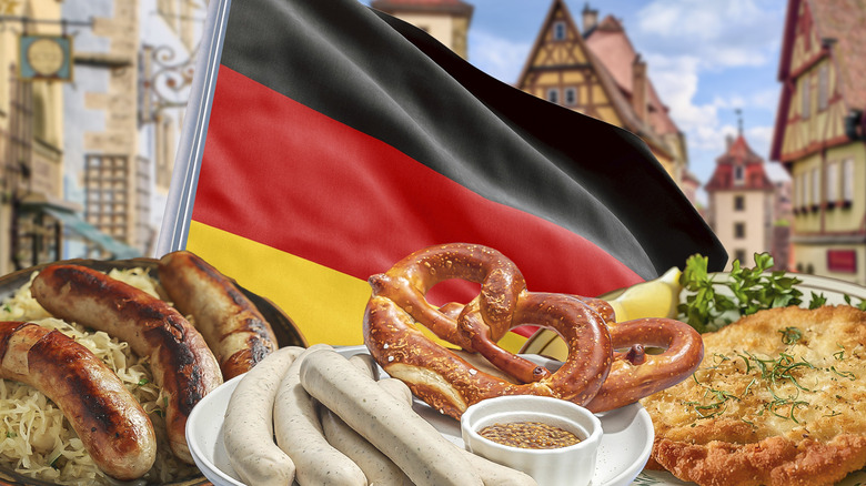 Plates of sausage, pretzels, and schnitzel in front of German flag