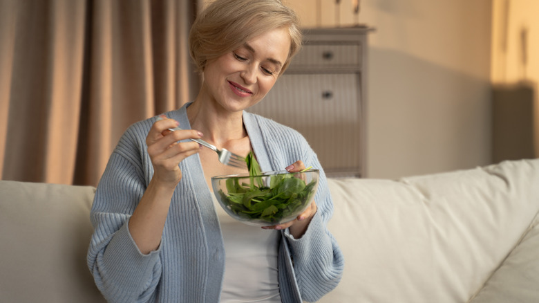 Someone enjoying a small spinach salad