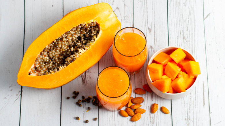 Halve and cubed papaya next to papaya juice