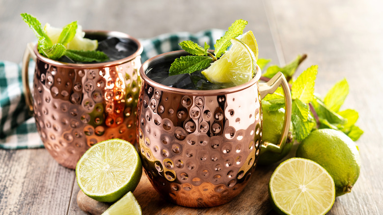 Moscow mules in classic metal cups with limes arranged around them.