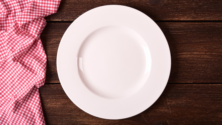 white plate on a scuffed wooden table