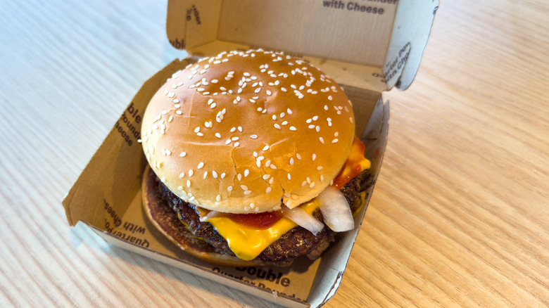 A McDonald's burger sitting in a brown cardboard box.