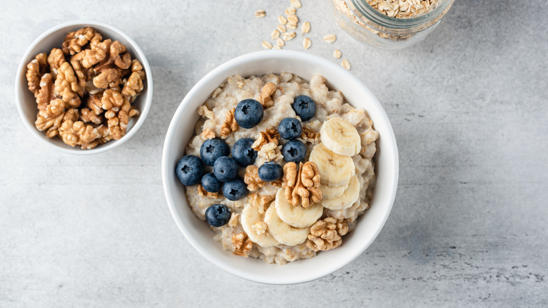 bowl of oatmeal with walnuts, banana, and blueberries
