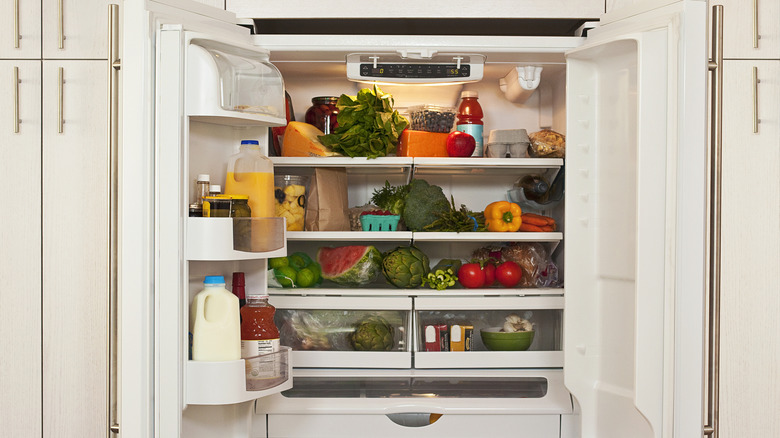 Open fridge with lots of colorful food inside