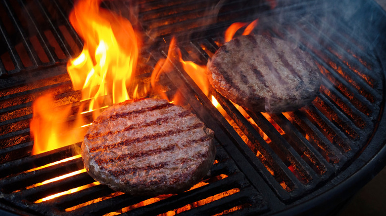 Close up of two hambrugers on a charcoal grill