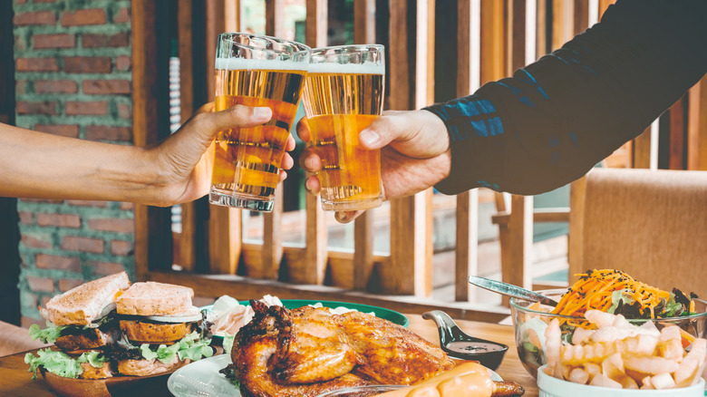 Friends clink beers over a table