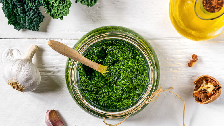 homemade kale pesto in a bowl surrounded by other ingredients