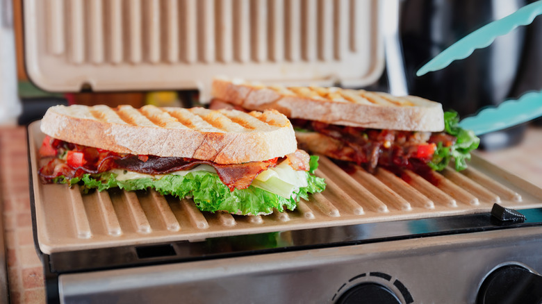 Two sandwiches cooking on a panini press