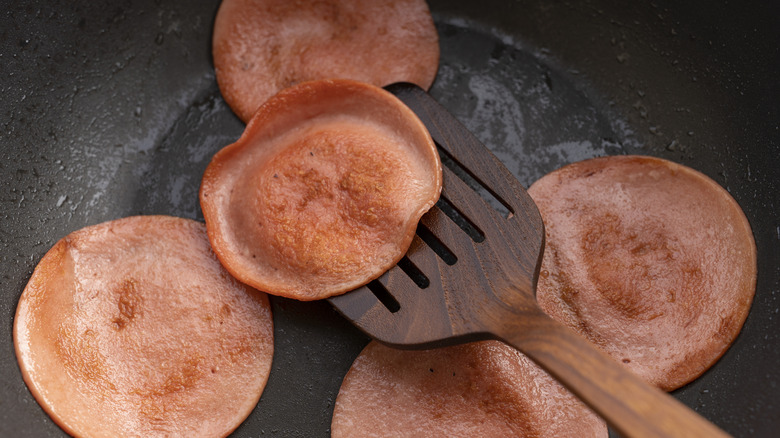 Frying sliced bologna in a pan