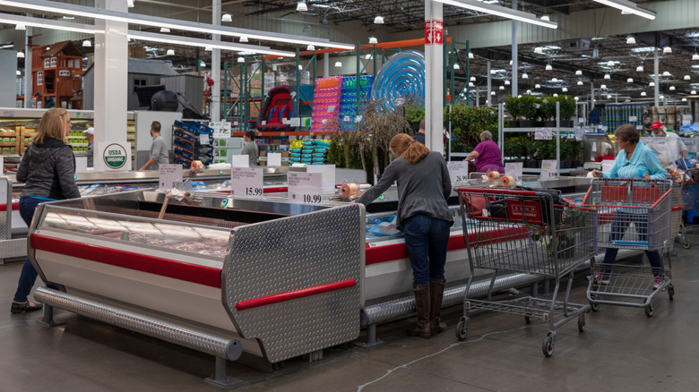 A Costco meat department with shoppers browsing