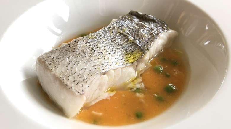 roasted hake fish with sauce sits in a bowl