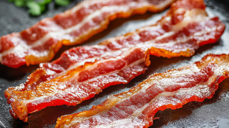 Three slices of cooked bacon.