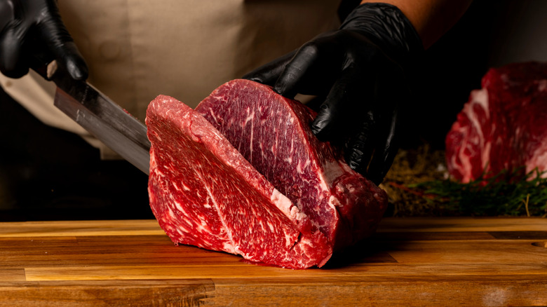 butcher slicing into beef