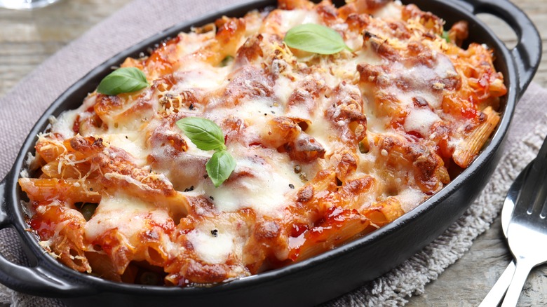 Al forno pasta in a baking dish on a wooden surface.