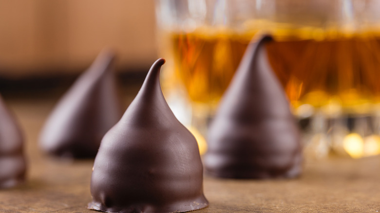 Chocolate truffles with blurred glass of bourbon in the background