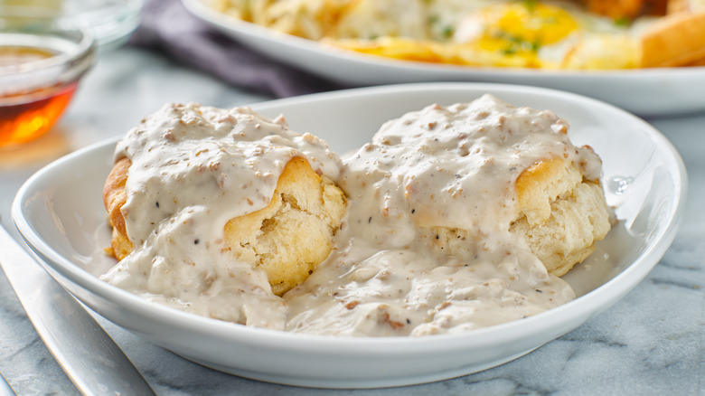 A plate of biscuits covered in gravy