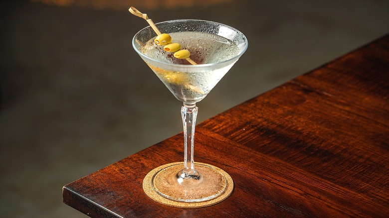 Classic chilled martini with olives on a wooden table