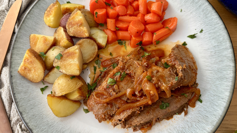 Braised brisket on plate with potatoes and carrots