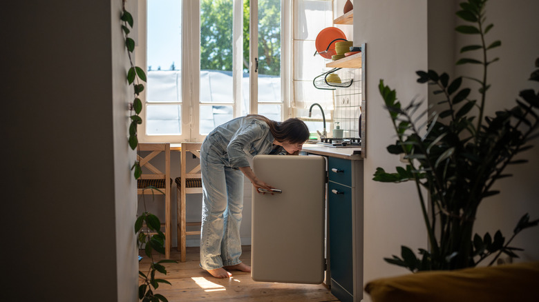 Woman looking into refrigerator in search of food