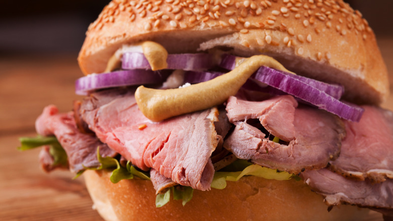 Close up of a roast beef sandwich on a seeded bun