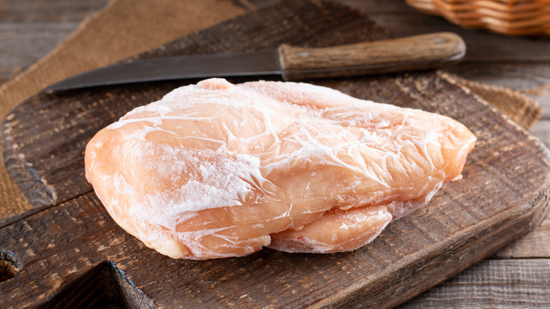 Frozen chicken breast on a cutting board