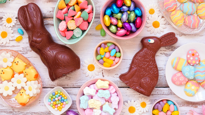 table decorated with flowers and bowls of various Easter candies