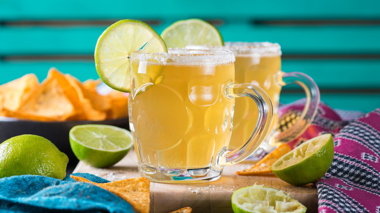 Two chelada cocktails served in mini stein glasses.