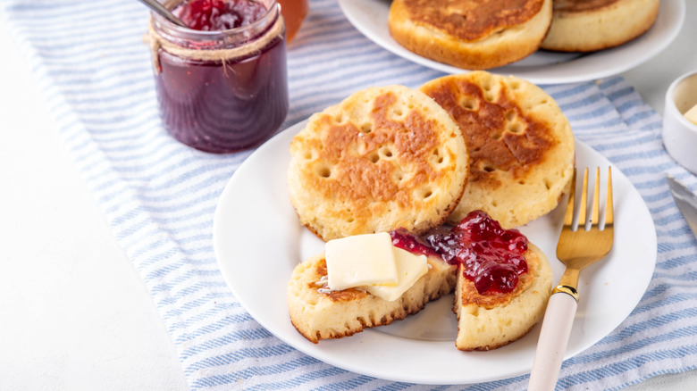 Plate of crumpets with jam and butter on top