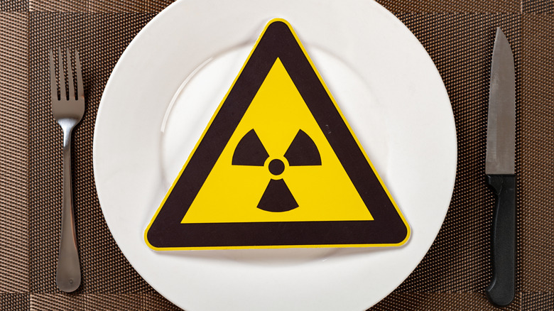 A radioactivity symbol over an empty plate