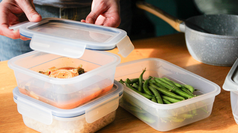 A person packing leftover food away.