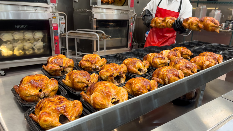 Worker preparing Costco's Roasted Rotisserie Chicken