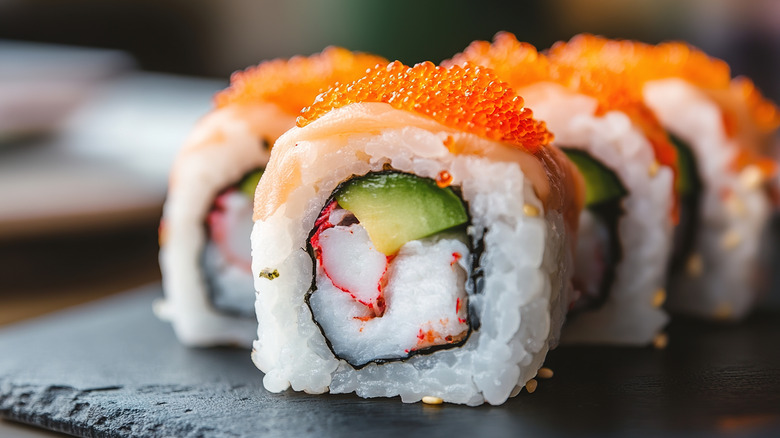 up close of California roll served on black tray