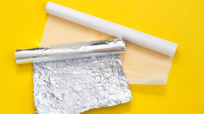 A roll of aluminum foil and parchment paper
