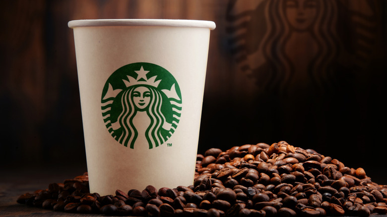 Starbucks cup next to coffee beans